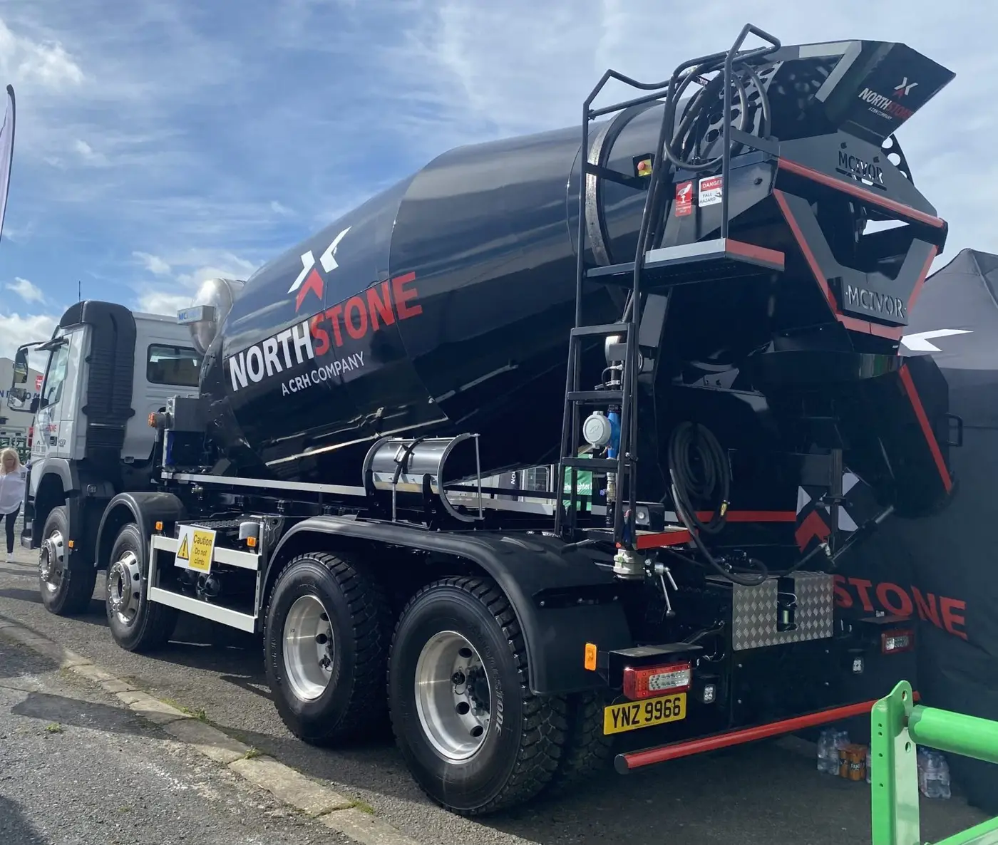 Rear view of a black concrete mixer with branding on the side