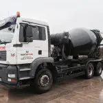 Side view of concrete truck mixer in action