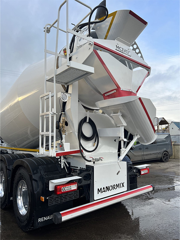 Truck mixer photographed on road with clear sky background